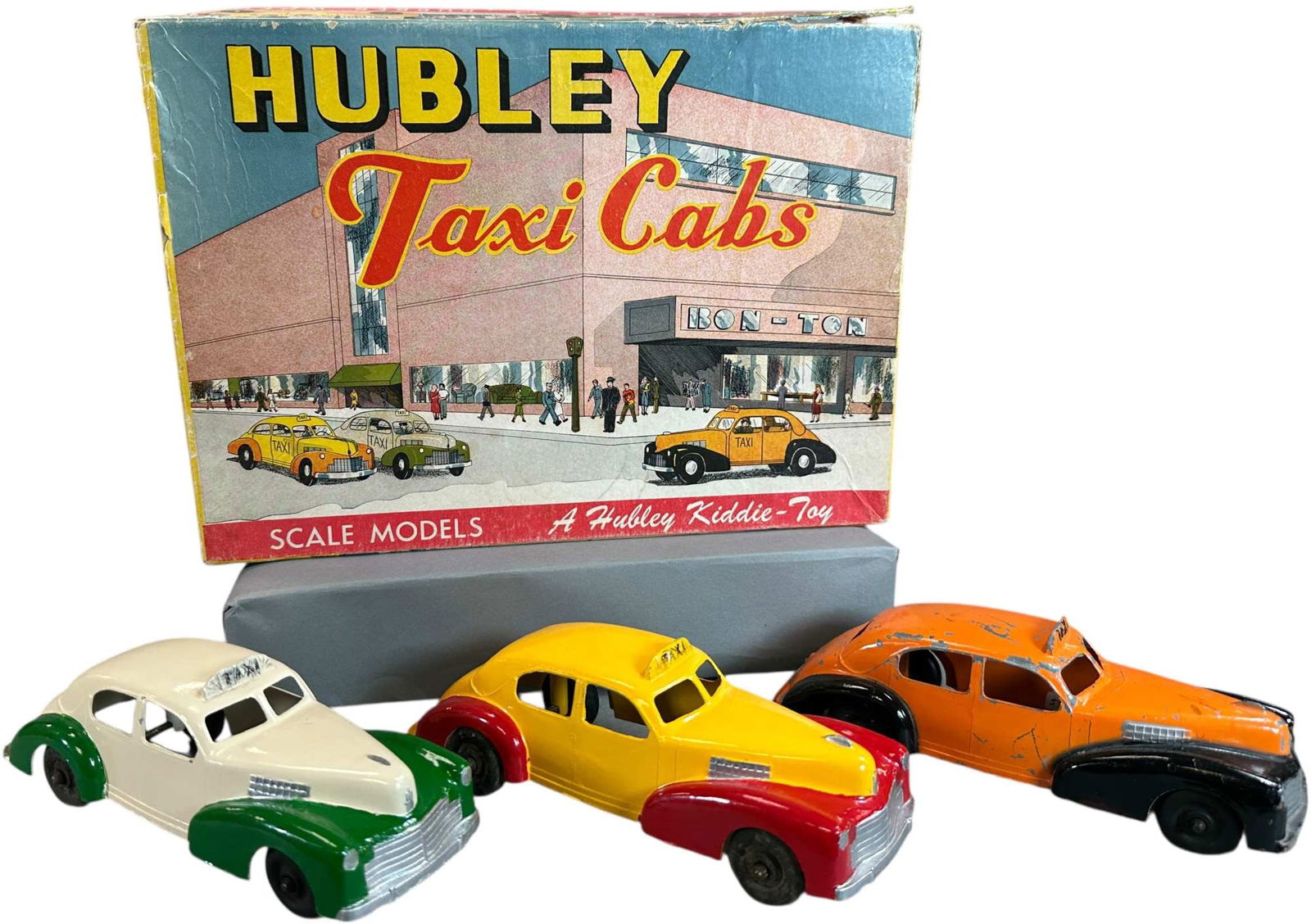 BOXED HUBLEY TAXI CAB SCALE MODEL SET: 52. BOXED HUBLEY TAXI CAB SCALE MODEL SET | 7" l. | Box has one torn corner seam, orange car is original, others repainted, (Very Good to Excellent Condition) | $200 - $400
