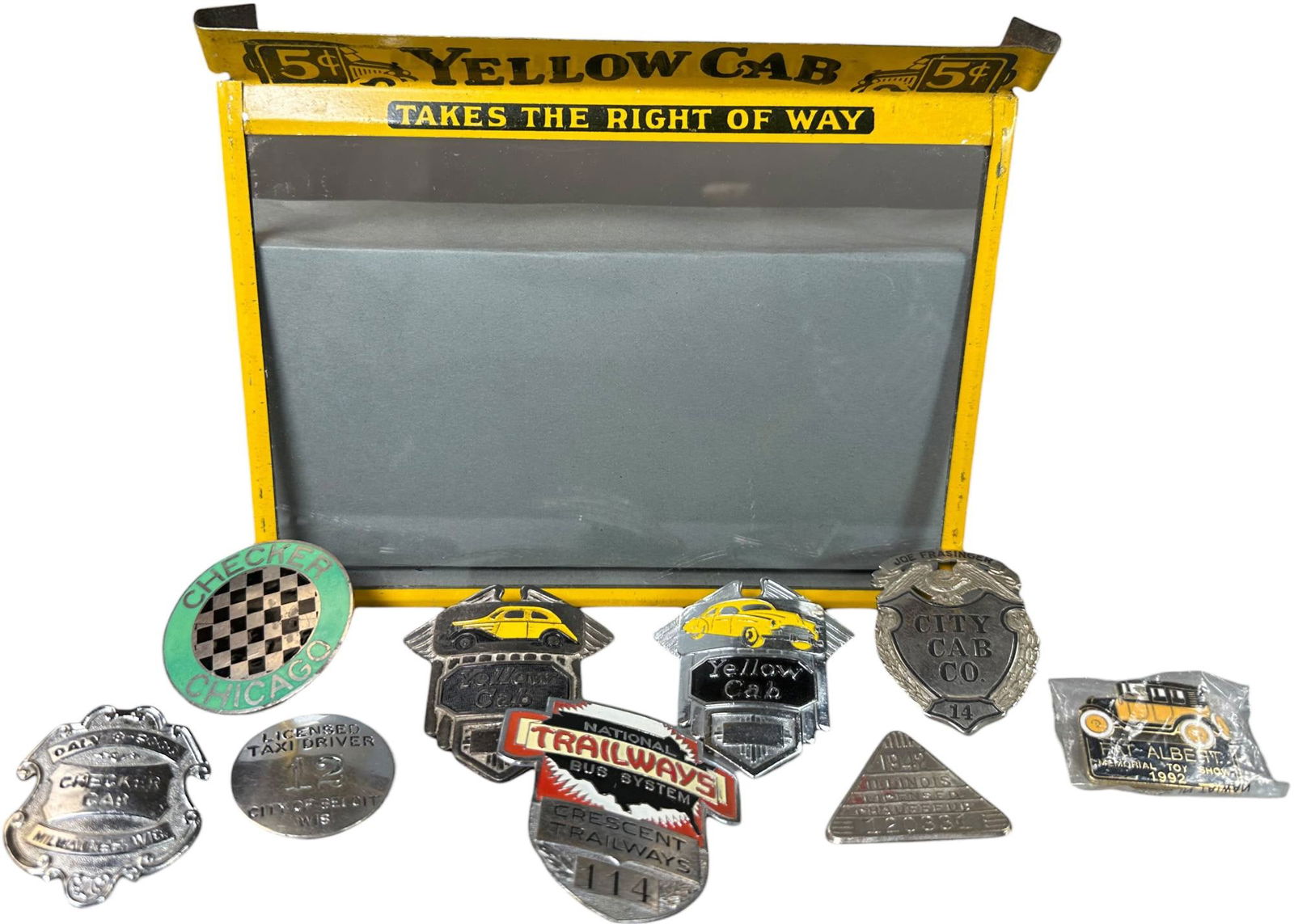 YELLOW CAB BADGE EPHEMERA GROUPING: 177. YELLOW CAB BADGE EPHEMERA GROUPING | 2.5" l. | Left corner of frame needs resoldering, otherwise (Excellent Condition) | $200 - $400