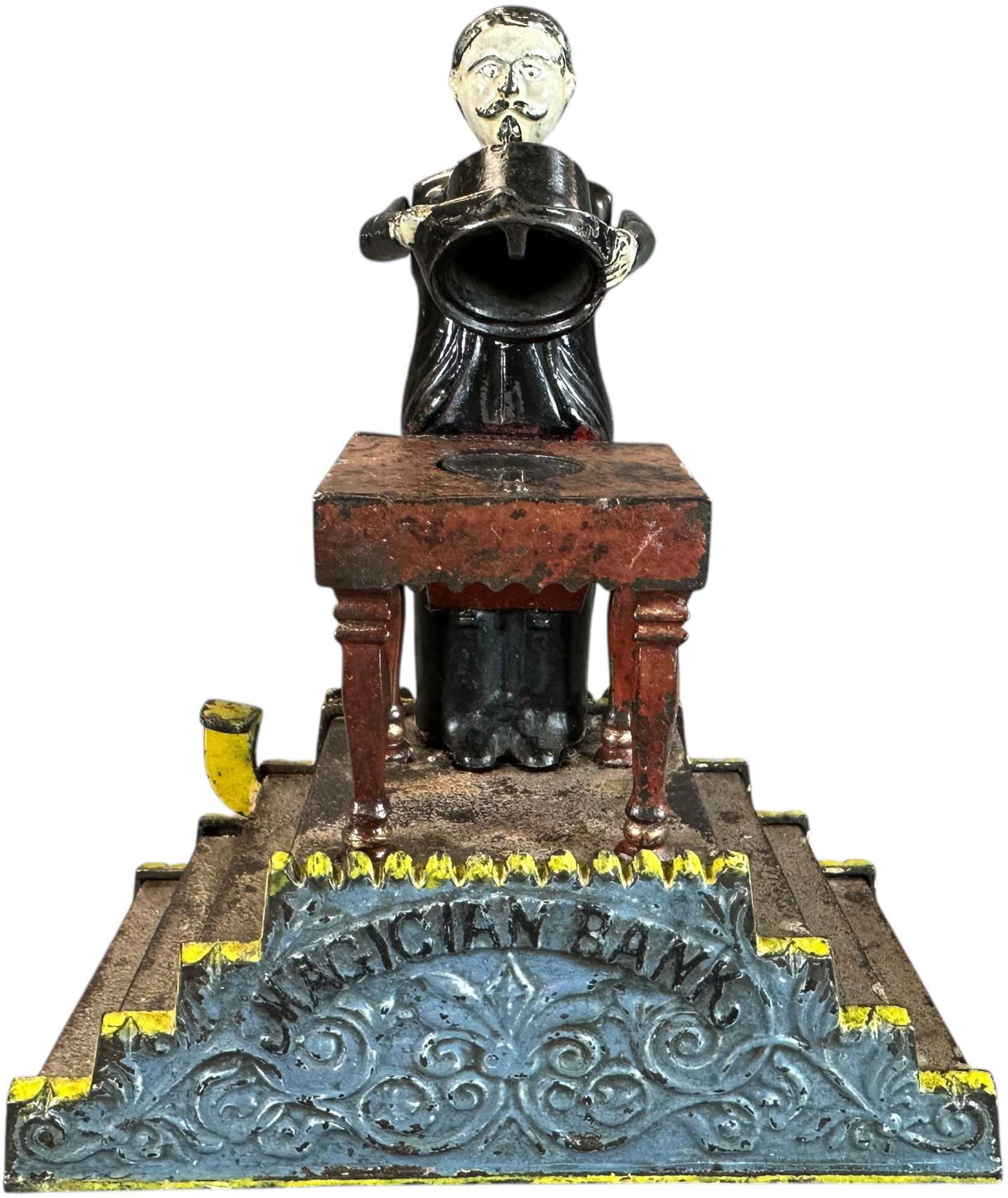 MAGICIAN MECHANICAL BANK: 213. MAGICIAN MECHANICAL BANK | J&E Stevens Co. | 8.5" h. | Authentic bank has some enhancement to face paint, one leg of table is repaired, displays in an (Excellent Condition) | $1,000 - $1,600