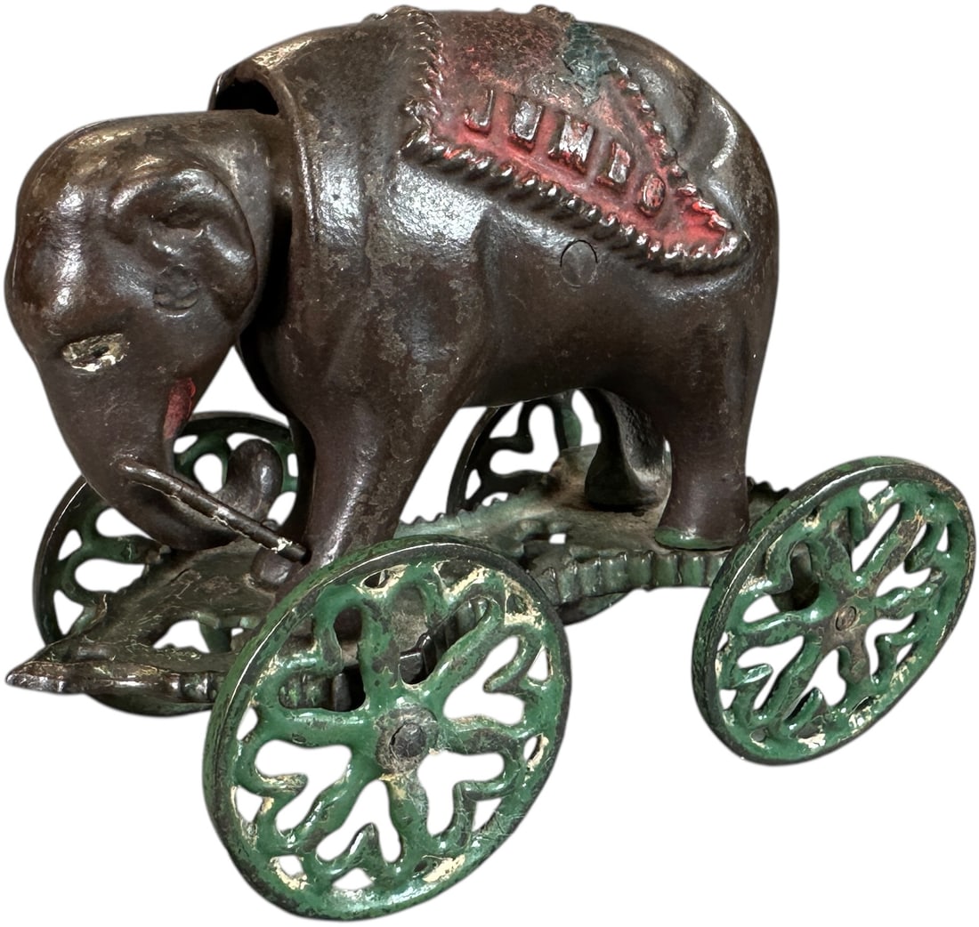 JUMBO SAVINGS W/ TUSKS MECHANICAL BANK: 351. JUMBO SAVINGS W/ TUSKS MECHANICAL BANK | J&E Stevens Co. | 4.5" l. | Two wheels are either repainted or replaced, otherwise original and unusual with tusks, (Very Good to Excellent Condition) |