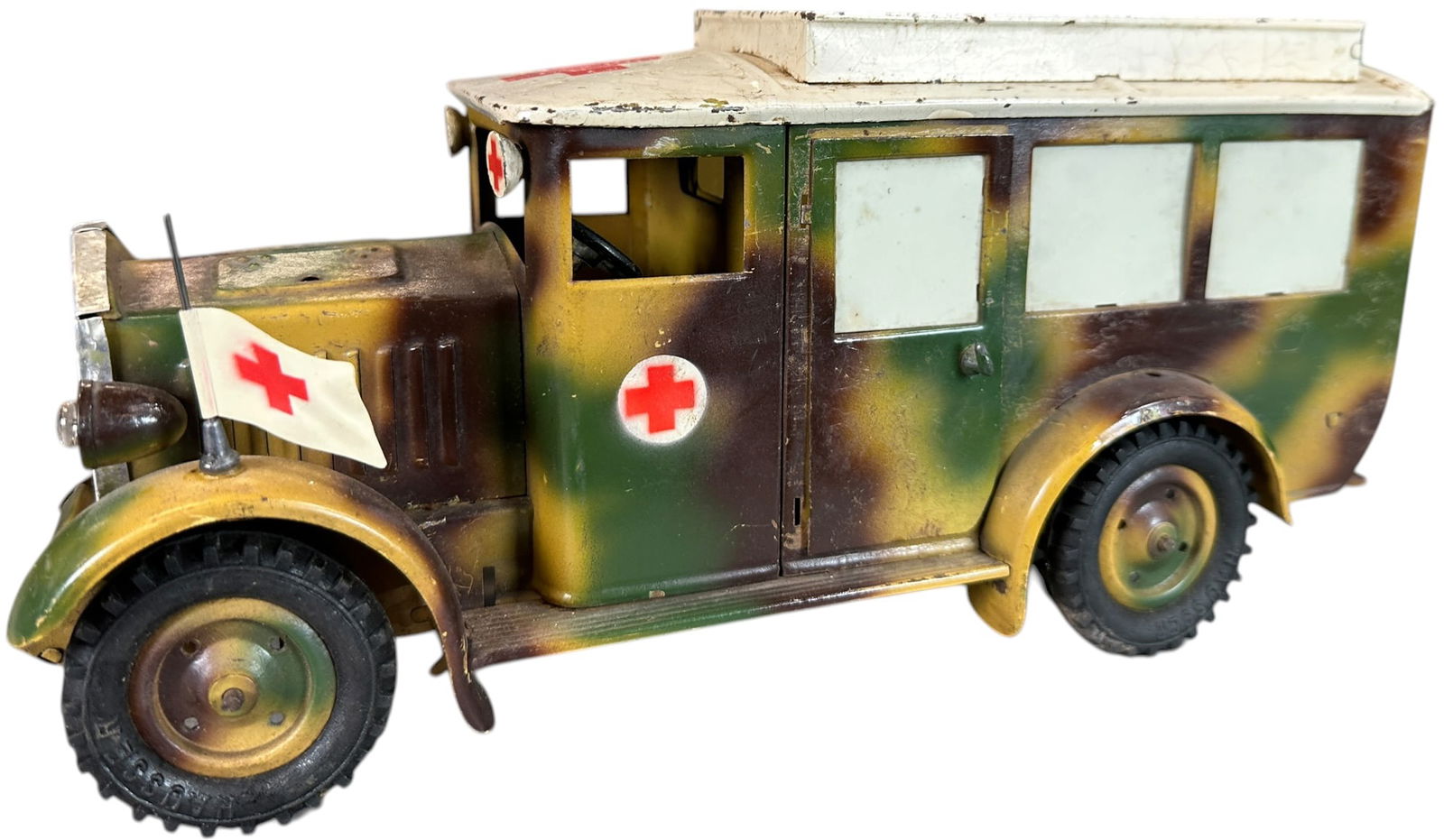 HAUSSER CAMOUFLAGED AMBULANCE: 22. HAUSSER CAMOUFLAGED AMBULANCE | Hausser ambulance with second version camouflage. From the Italian collection of Steno Tonelli. | 11 " l. | Motor missing, side door hinge broken, tires replaced; o
