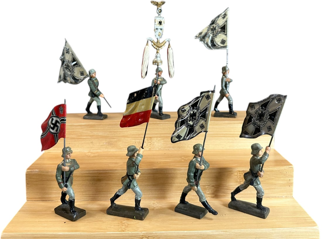 LINEOL MARCHING GERMAN FLAG BEARERS: 40. LINEOL MARCHING GERMAN FLAG BEARERS | Seven Soldiers in four different poses carrying tin flags, one soldier carries a large schellenbaum. From the Italian collection of Steno Tonelli. | 75 mm | (