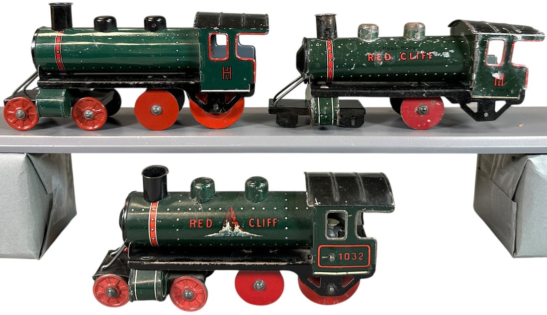 THREE VARIATIONS OF HESS RED CLIFF LOCOMOTIVE: 95. THREE VARIATIONS OF HESS RED CLIFF LOCOMOTIVE | The last locomotive Hess made, three different versions. Provenance: The Chuck Ehlers Hess Collection. | 6" l. loco | One engine is missing wheels,