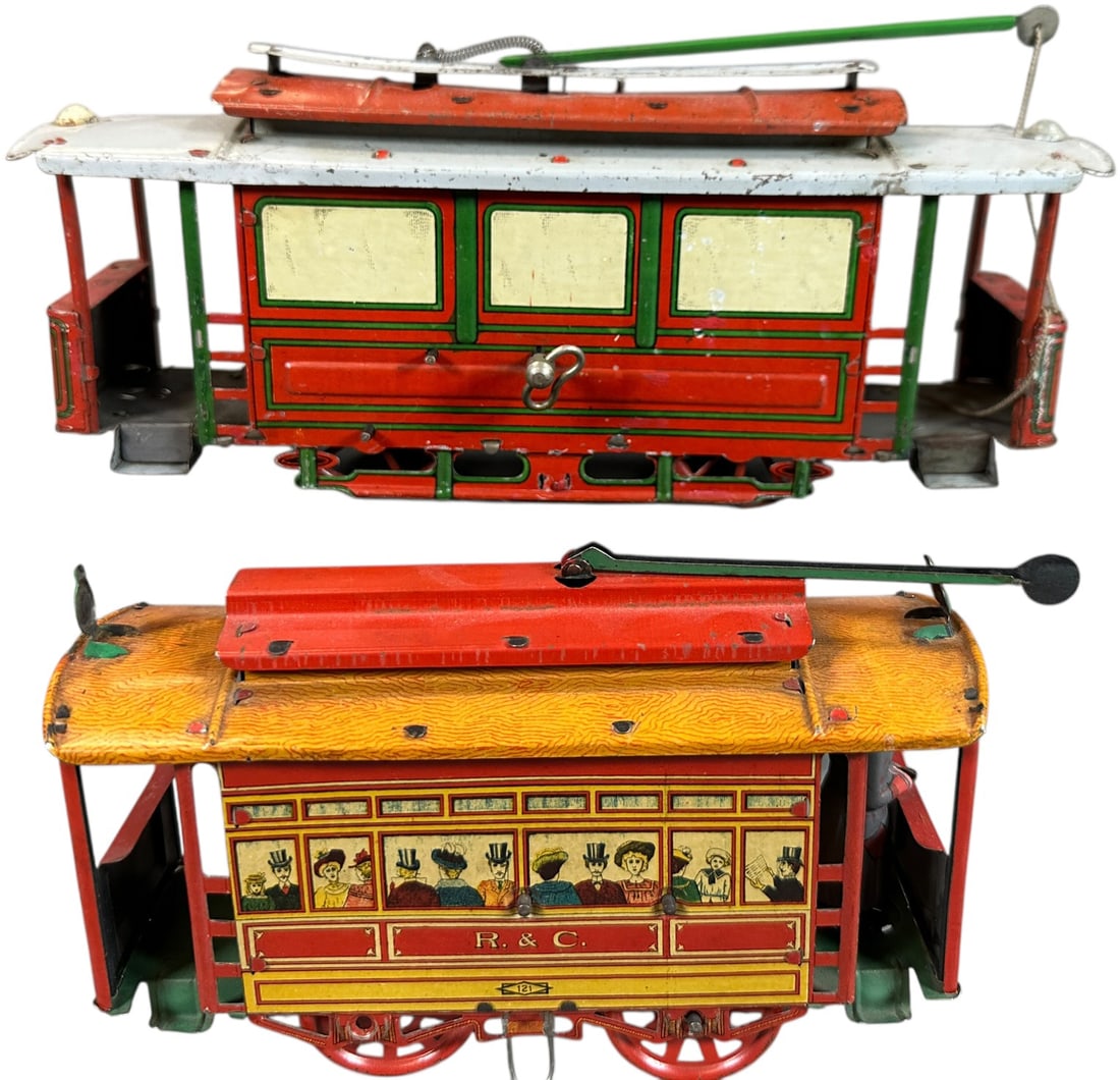 TWO RICHTER WIND-UP TROLLEYS: 98. TWO RICHTER WIND-UP TROLLEYS | Wind-up, litho, floor toys. | 10" l. loco | Larger centenary pole is replaced, touch up to post hinge on smaller roof, (Very Good to Excellent Condition) | $300 - $6