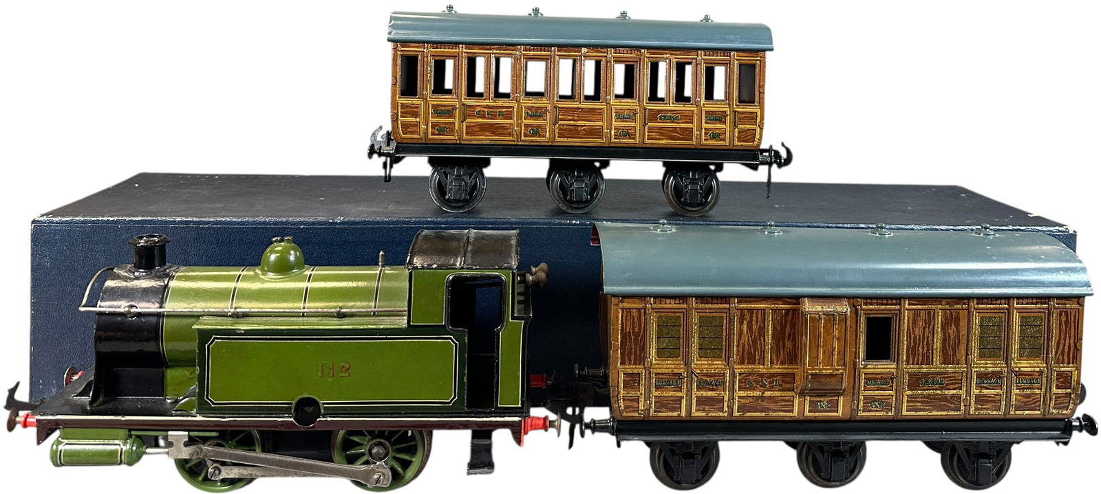 BASSETT LOWKE 112 TANK LOCO W/ CARETTE CARS: 126. BASSETT LOWKE 112 TANK LOCO W/ CARETTE CARS | Gauge 1, clockwork, hand painted loco with litho cars. Ex: The Tony Cuff UK Collection. | 9.5" l. loco | Coach roofs are repainted, some professional