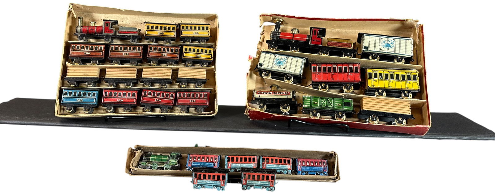 BOXED PENNY TOY TRAIN SETS: 137. BOXED PENNY TOY TRAIN SETS | Provenance: The Chuck Ehlers Hess Collection. | 14" l., 35" l., 36" l. sets | Split to side of original lid, (Pristine to Near Mint Condition) | $400 - $800