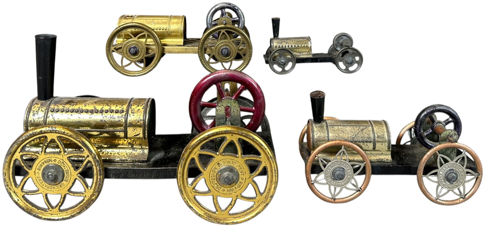 FOUR EARLY HESS FLYWHEEL LOCOMOTIVES: 158. FOUR EARLY HESS FLYWHEEL LOCOMOTIVES | Provenance: The Chuck Ehlers Hess Collection. | 7" l. | Missing one cow catcher, otherwise (Very Good Condition) | $400 - $800