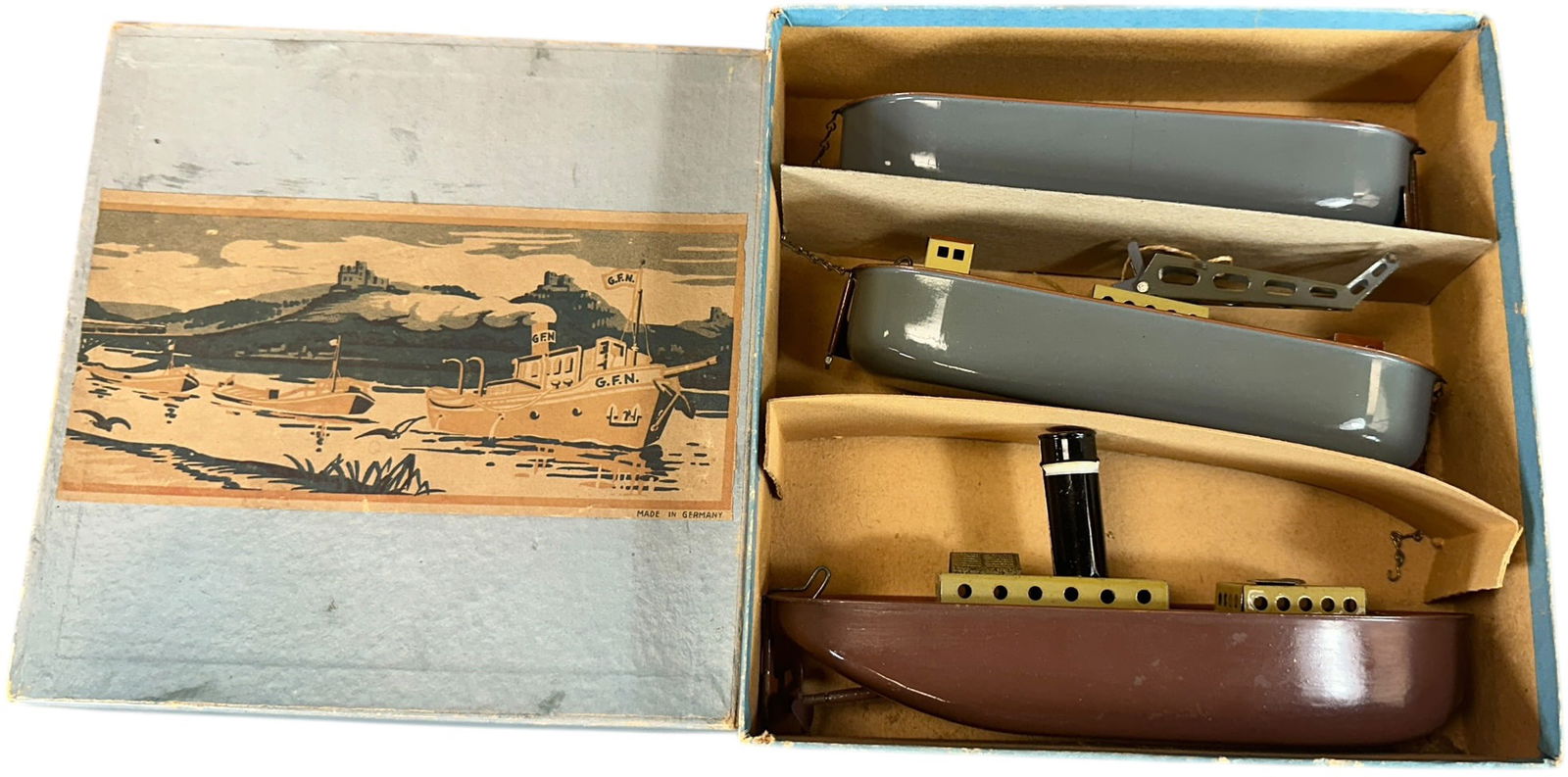 FLEISCHMANN TUGBOAT BOXED SET: 192. FLEISCHMANN TUGBOAT BOXED SET | 310 tug and barge, crane barge, c. 1936 catalog. | 7.5" l. | Very well preserved set, box dividers present but loose, (Pristine Condition) | $400 - $800