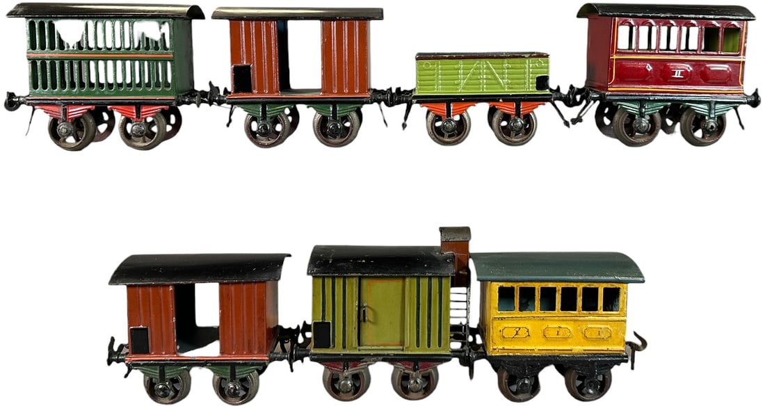 EARLY BING HAND PAINTED TRAIN CARS: 215. EARLY BING HAND PAINTED TRAIN CARS | Gauge 1, hand painted, some with cast iron wheels. | 5" l. | Touch-up to yellow car, overall (Excellent Condition) | $400 - $800