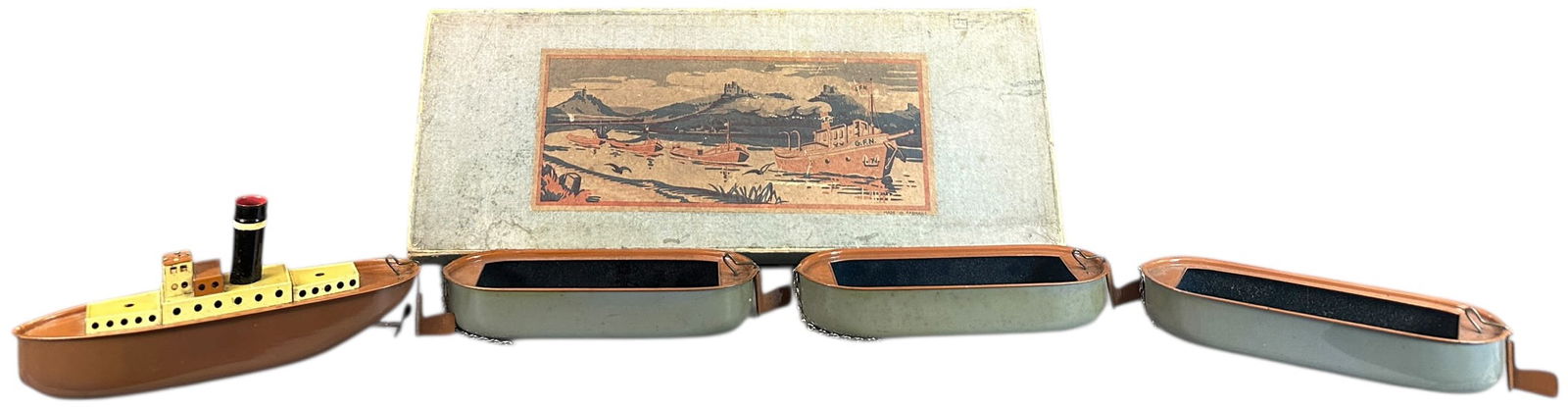 FLEISCHMANN 310 BOXED TUG BOAT SET: 261. FLEISCHMANN 310 BOXED TUG BOAT SET | With 3 open barges. | 7.5" l. | Minor seam splits to complete original box, boats are in (Pristine Condition) | $300 - $600