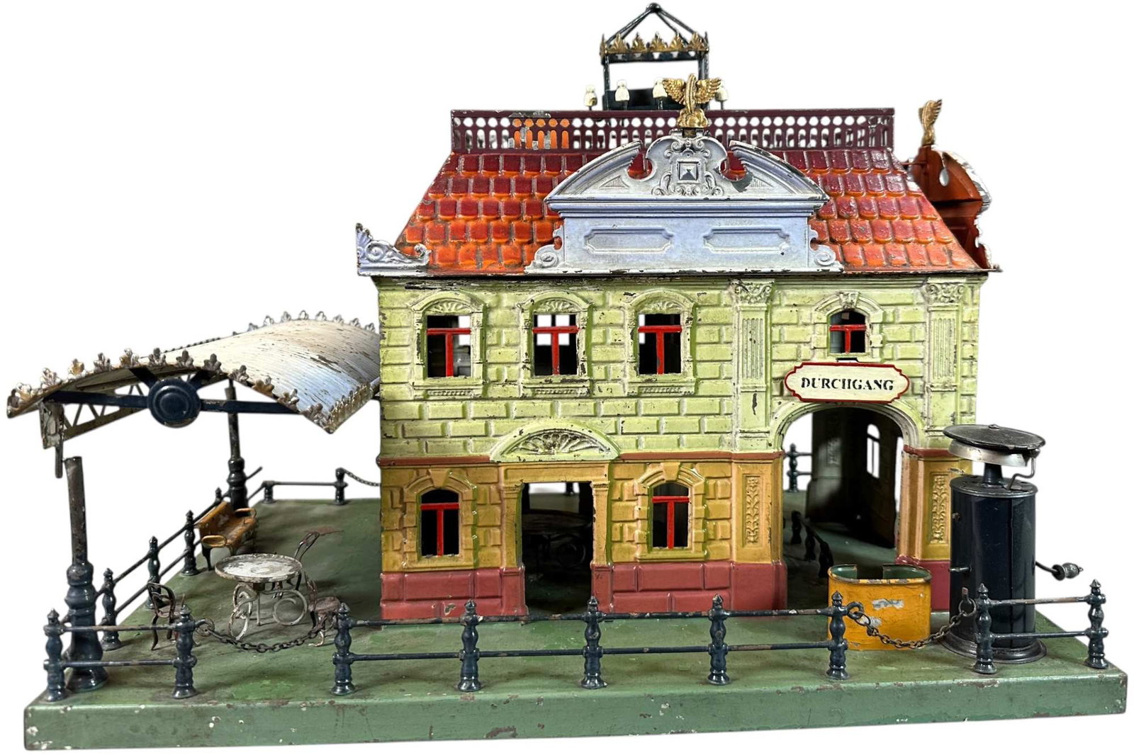 EARLY BING STATION W/ AWNING: 1222. EARLY BING STATION W/ AWNING | Germany, hand painted, catalog no.13175, circa 1912. | 17" l. | Touch-up to top of green roof and green base, replaced gold finials & electric wires on top, (Very 