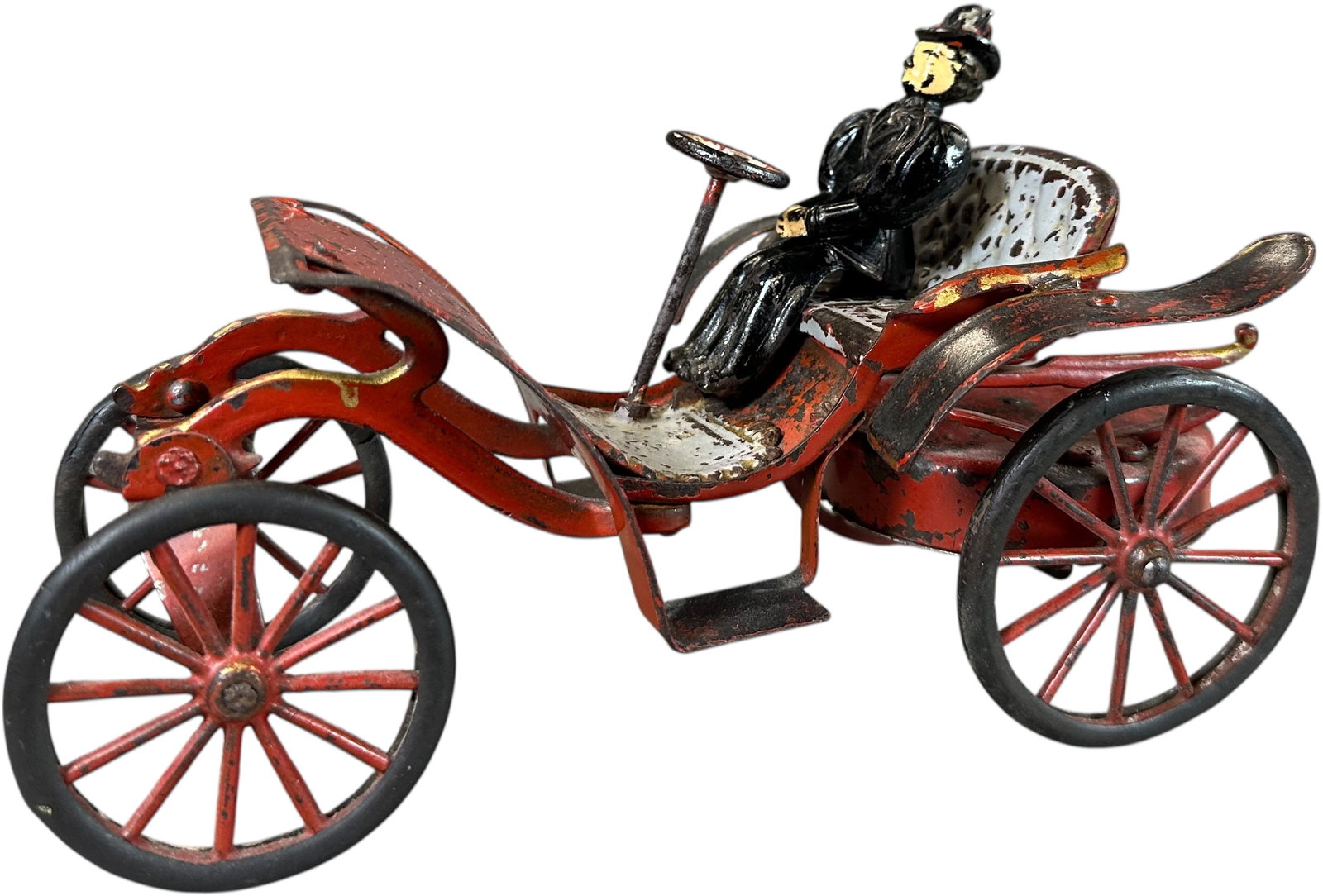 WILKINS KINGSBURY HORSELESS PHAETON: 1480. WILKINS KINGSBURY HORSELESS PHAETON | USA, wind-up motor driven. Early example with open front end where the bonnet eventually appears. | 9" l. | Authentic figure with repainted flesh is added, 