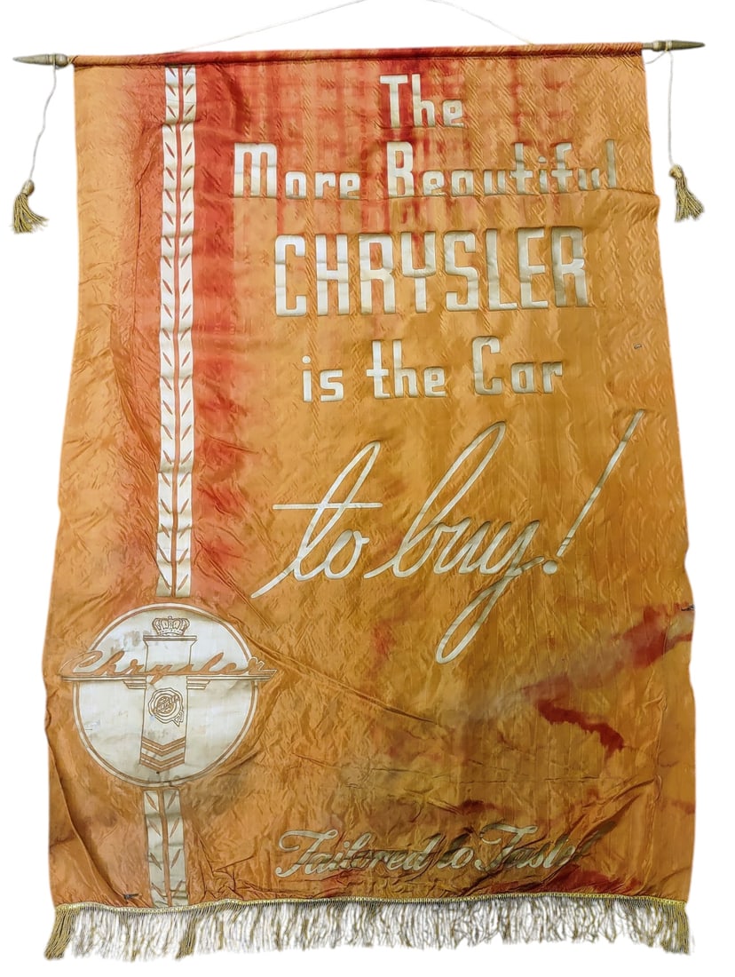1941 CHRYSLER DEALERSHIP BANNER: 95. 1941 CHRYSLER DEALERSHIP BANNER | Large Chrysler dealership showroom banner, circa 1941, printed on silk with decorative fringe and wood hanging rod, featuring the slogan "The More Beautiful Chrys