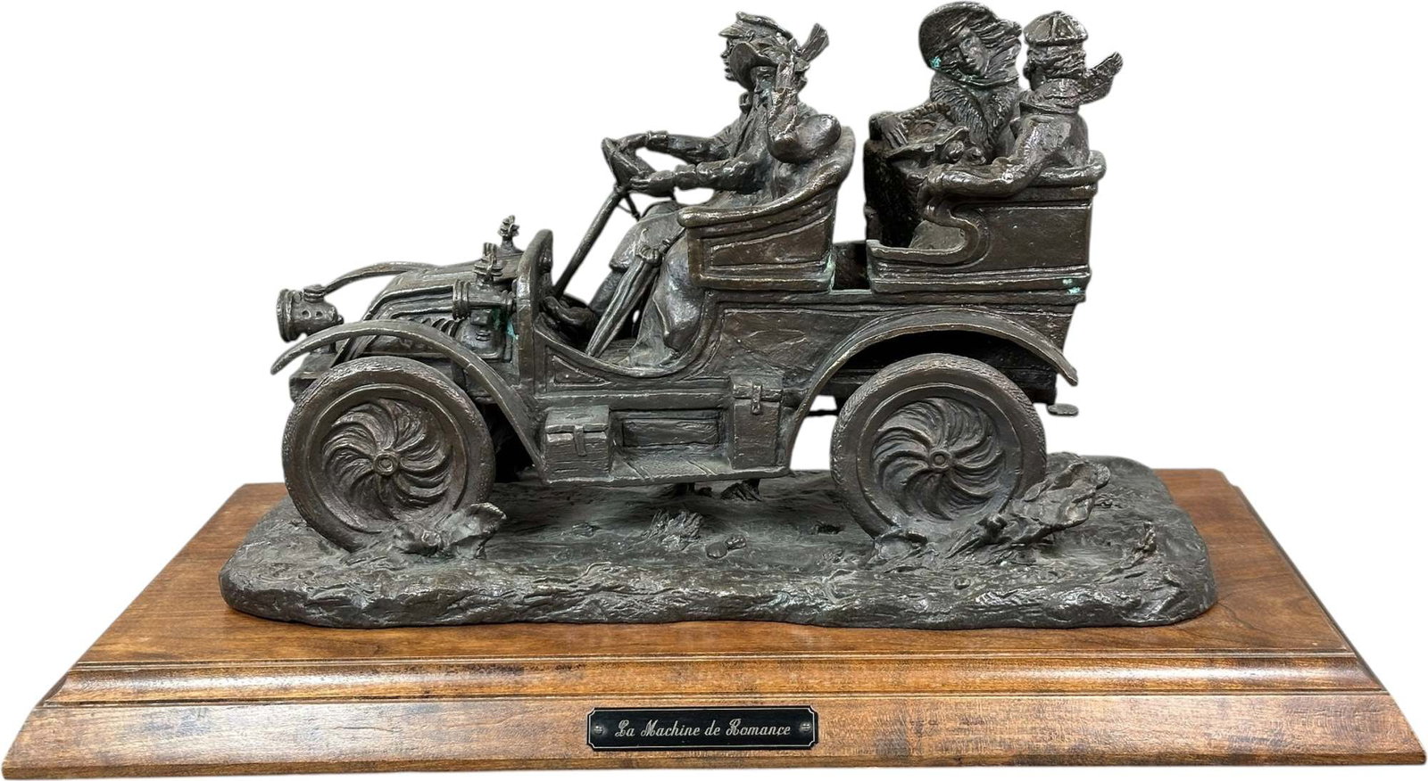 LA MACHINE DE ROMANCE BRONZE SCULPTURE: 100. LA MACHINE DE ROMANCE BRONZE SCULPTURE | depicting four fashionable passengers enjoying an outing in an early open touring automobile, with the chauffeur at the wheel navigating a rugged country 