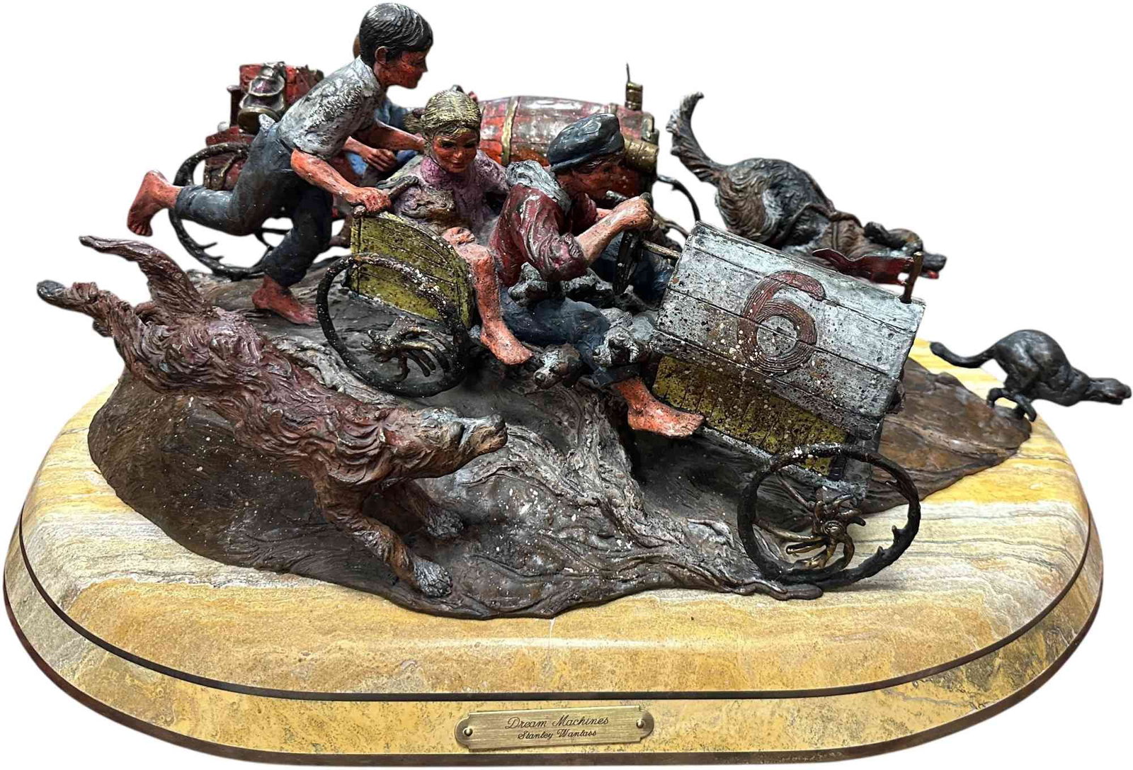 STANLEY WANLASS DREAM MACHINES BRONZE SCULPTURE: 102. STANLEY WANLASS DREAM MACHINES BRONZE SCULPTURE | Hand-painted polychrome bronze sculpture by Stanley Wanlass, depicting three youngsters racing a handcrafted soapbox car with faithful canine com