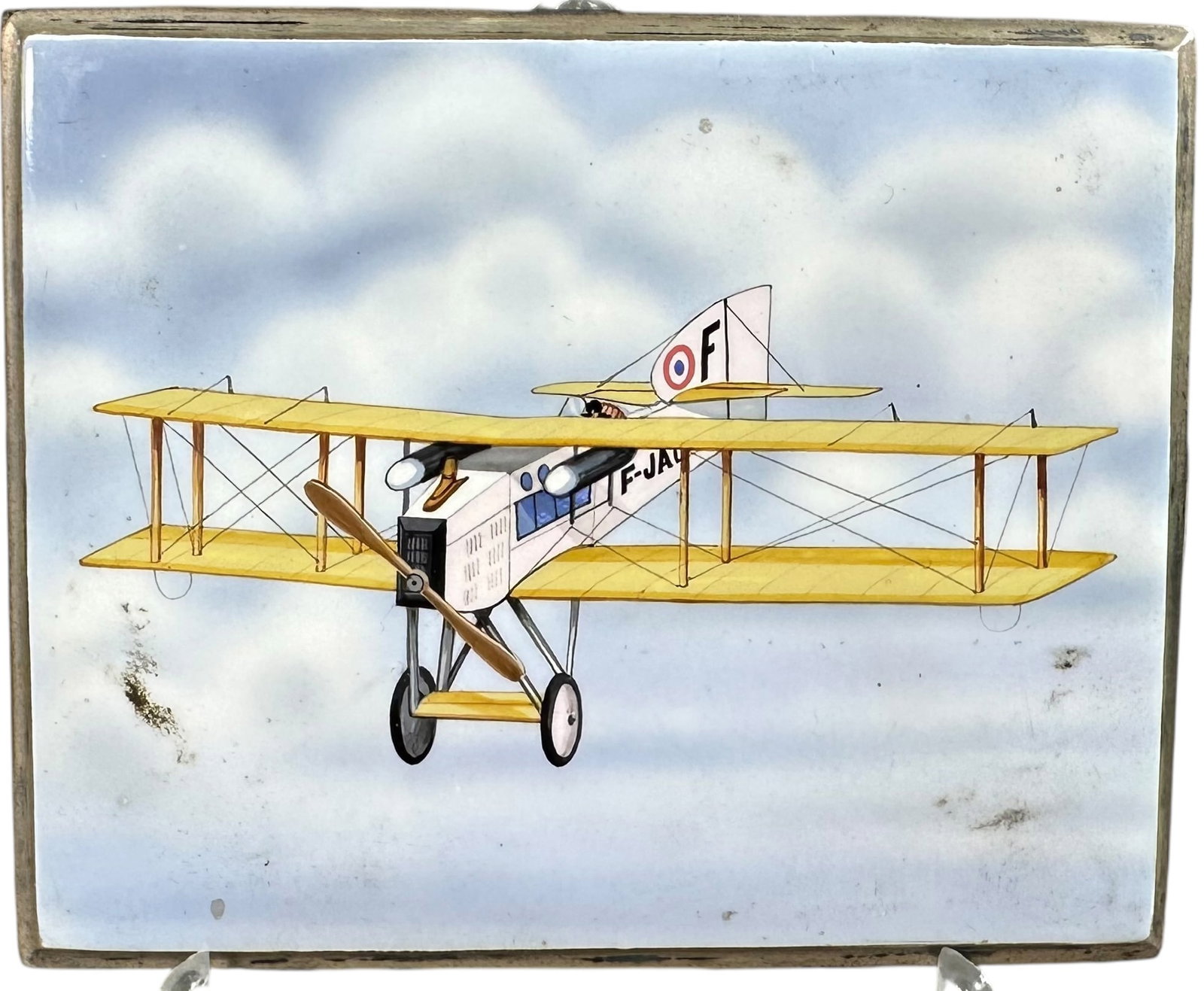 ENAMELED AVIATION CIGARETTE CASE: 158. ENAMELED AVIATION CIGARETTE CASE | Silver plated metal, silver tone interior. From the David Bausch Automobilia Collection. | 3.5" l. | Contains one complete and one partial interior elastic stra