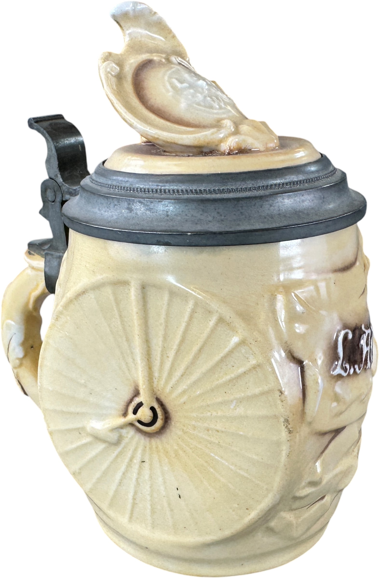 GERMAN C.A.W. CYCLISTS BEER STEIN: 204. GERMAN C.A.W. CYCLISTS BEER STEIN | Germany, circa 1900?1915. Stoneware beer stein with pewter-mounted lid, molded in the form of a bicycle wheel and decorated in relief with the initials