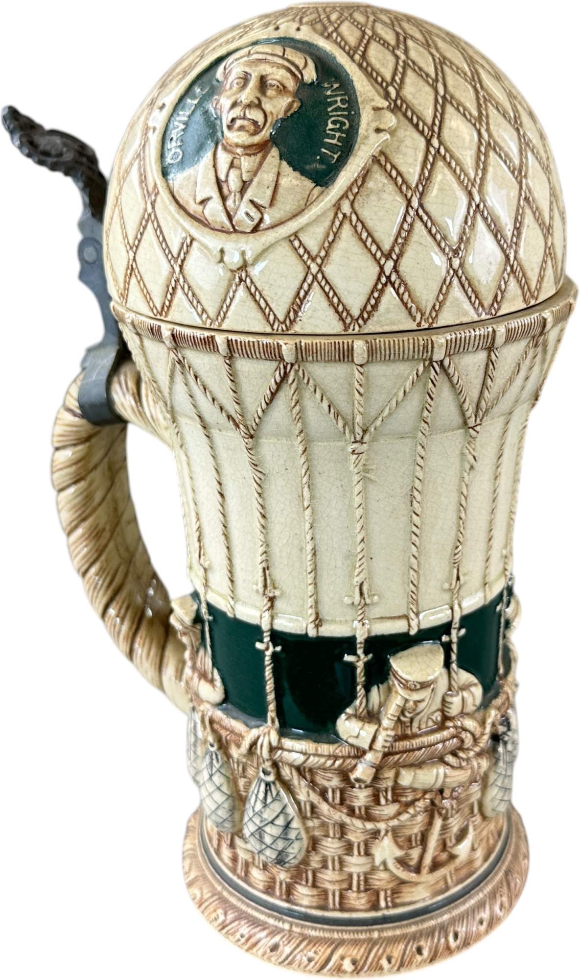 WRIGHT BROTHERS BALLOON BEER STEIN: 208. WRIGHT BROTHERS BALLOON BEER STEIN | Germany, circa 1905?1915. Stoneware beer stein with pewter-mounted lid molded as a hot air balloon, commemorating early aviation with portraits of the Wright 