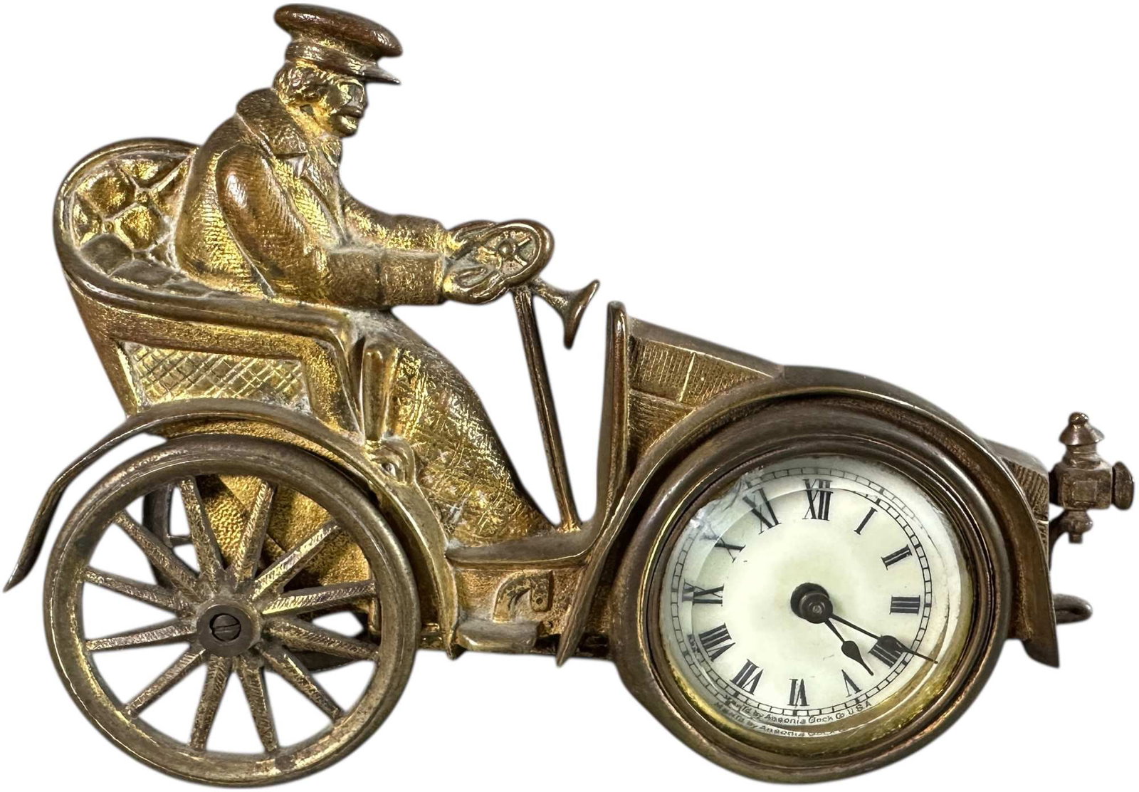 BRASS AUTOMOBILE MOTIF DESK CLOCK: 297. BRASS AUTOMOBILE MOTIF DESK CLOCK | From the David Bausch Automobilia Collection. | 7" l. | 1892 clock not tested, minor chip to glass, overall (Very Good to Excellent Condition) | $600 - $900