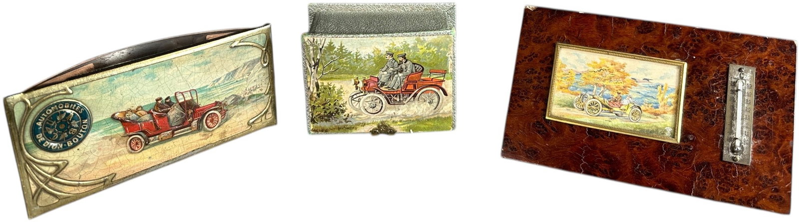 EARLY LITHOGRAPH AUTOMOBILE DESK ITEMS: 404. EARLY LITHOGRAPH AUTOMOBILE DESK ITEMS | Ink blotter, desk thermometer, and a trinket box. From the David Bausch Automobilia Collection. | 6.5" l. | (Excellent Condition) | $200 - $400