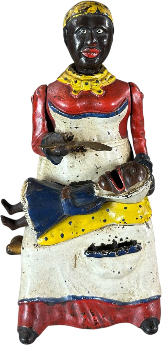 MAMMY & CHILD MECHANICAL BANK: 18. MAMMY & CHILD MECHANICAL BANK | Kyser & Rex Mfg. Provenance: The Robert Booth Jr. Collection. | CULTURAL DISCLAIMER: Certain antique and vintage items in this sale include imagery or themes that r