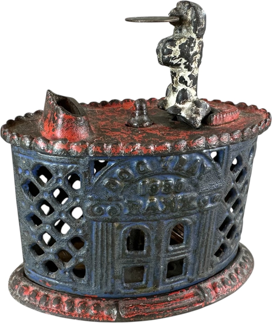DOG TRAY MECHANICAL BANK: 46. DOG TRAY MECHANICAL BANK | Kyser & Rex Mfg., scarce example with nice red, white and blue color scheme. Provenance: The Robert Booth Jr. Collection. | 4.5" h. | (Very Good Condition) | $1,200 -