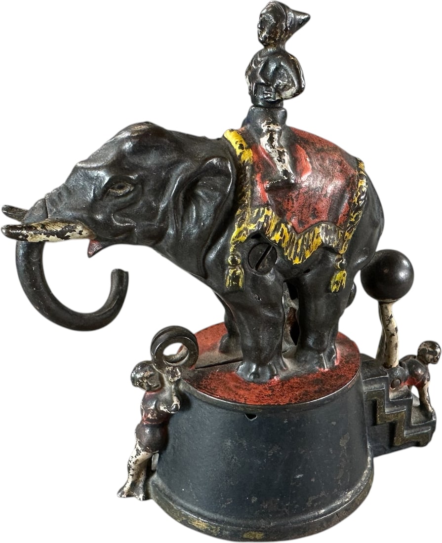 ELEPHANT & THREE CLOWNS MECHANICAL BANK: 52. ELEPHANT & THREE CLOWNS MECHANICAL BANK | J&E Stevens Co., coin is placed in rings at front, move legs on clown with ball and elephant swings trunk to deposit coin. Provenance: The Robert Booth Jr