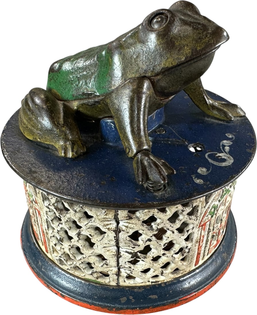 FROG ON LATTICE MECHANICAL BANK: 95. FROG ON LATTICE MECHANICAL BANK | J&E Stevens Co. Provenance: The Robert Booth Jr. Collection. | 4.5" l. | Enhanced red paint along bottom edge of base, (Very Good to Excellent Condition) | $400