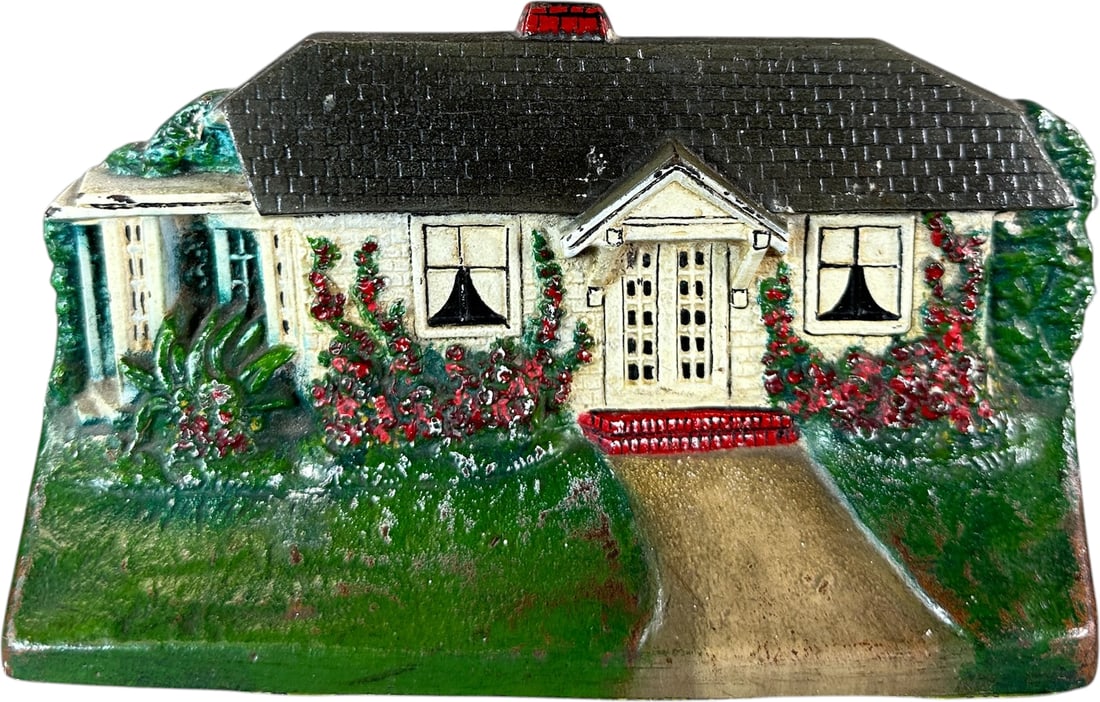 CJO COTTAGE DOORSTOP: 147. CJO COTTAGE DOORSTOP | Marked "cJo 1283," path leading to red brick step of white house with gray roof, fine detailed casting. Ex: The Bob Brady Collection. | 4.5" h. | (Near Mint Condition) |