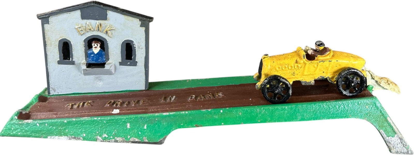 REYNOLDS THE DRIVE IN MECHANICAL BANK: 211. REYNOLDS THE DRIVE IN MECHANICAL BANK | Catalogue # 3-M, 1971, Edition of 10. Ex: Max Berry Collection. | 17" l. | (Very Good Condition) | $250 - $500
