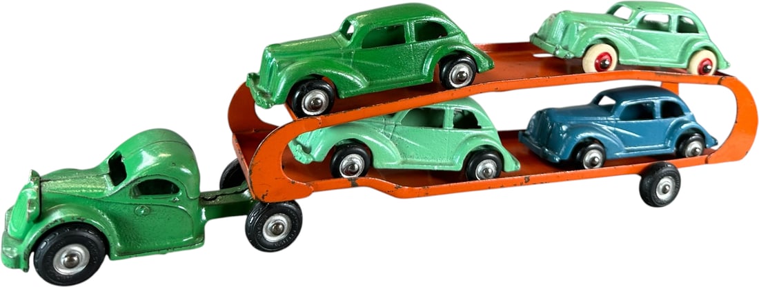 ARCADE CAR CARRIER W/ FOUR AUTOS: 341. ARCADE CAR CARRIER W/ FOUR AUTOS | Provenance: Ira Bernstein Collection. | 15.5" l. | Blue car and one green are overpainted, one green has minor touch-ups, (Very Good to Excellent Condition) | $