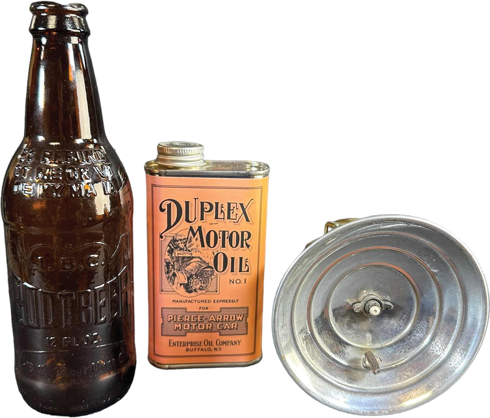 ROOT BEER BOTTLE W/ OIL HEADLIGHT AND: 167. ROOT BEER BOTTLE W/ OIL HEADLIGHT AND | MOTOR OIL IBC Root Beer, Duplex Motor Oil, and Autolite Lamp. | Bottle 8" h. | Oil can is contemporary, others in (Very Good to Excellent Condition) | $40 