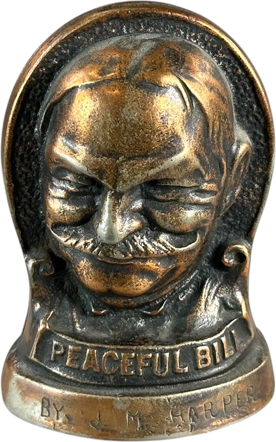 SMILING JIM PEACEFUL BILL STILL BANK: 205. SMILING JIM PEACEFUL BILL STILL BANK | JM Harper, c. 1908. | 4.5" h. | (Excellent Condition) | $600 - $900