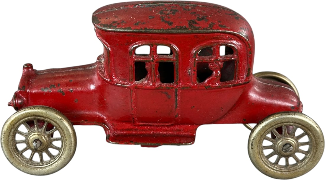 AUTO W/ PASSENGER STILL BANK: 215. AUTO W/ PASSENGER STILL BANK | AC Williams, red version. | 7" l. | Chipping is primarily at the roof, all original in (Excellent Condition) | $400 - $700