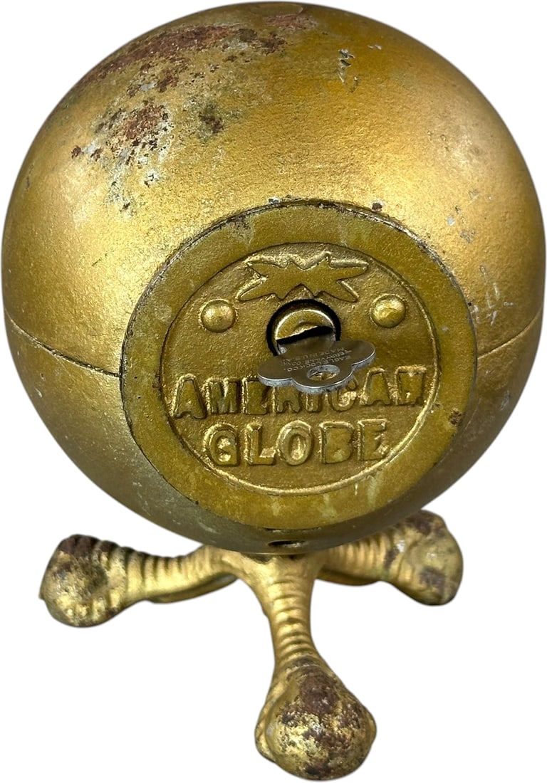 AMERICAN GLOBE STILL BANK: 220. AMERICAN GLOBE STILL BANK | US, maker unknown. | 5.5" h. | Some overpaint to gold on globe, (Very Good to Excellent Condition) | $150 - $300