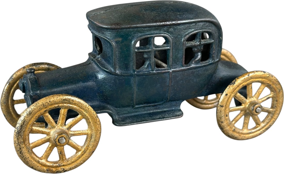 AUTO W/ PASSENGER STILL BANK: 237. AUTO W/ PASSENGER STILL BANK | AC Williams, blue version. | 7" l. | Greenish blue paint is old overpaint which does not reflect poorly under blacklight UV, (Very Good to Excellent Condition) | $3