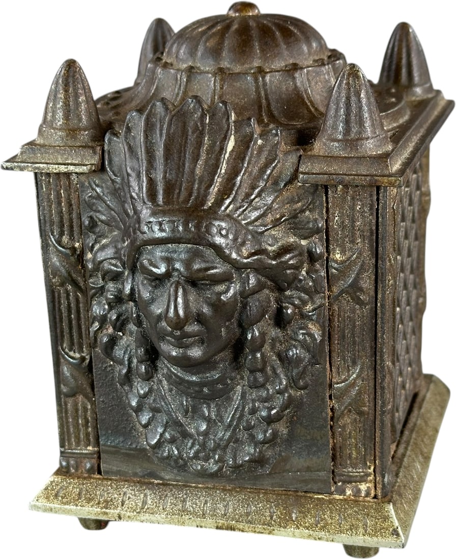 FOUR POSTED SAFE STILL BANK - INDIAN: 381. FOUR POSTED SAFE STILL BANK - INDIAN | Grey Iron Casting Co. - same as combination safe p.28 Safe book. | 4.5" h. | Appears to be a conversion safe with Indian plaque added, minor repair to one