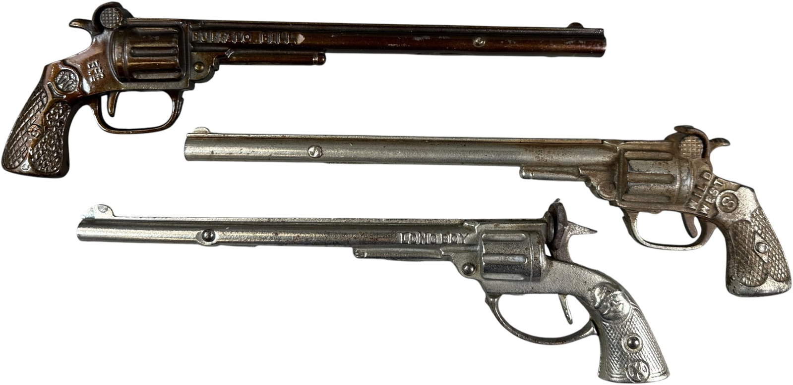 BUFFALO BILL, LONGBOY AND WILD WEST CAP GUNS: 487. BUFFALO BILL, LONGBOY AND WILD WEST CAP GUNS | 11.5" l. | Long Boy missing spring, Wild West has crack in barrel, otherwise (Very Good to Excellent Condition) | $200 - $400