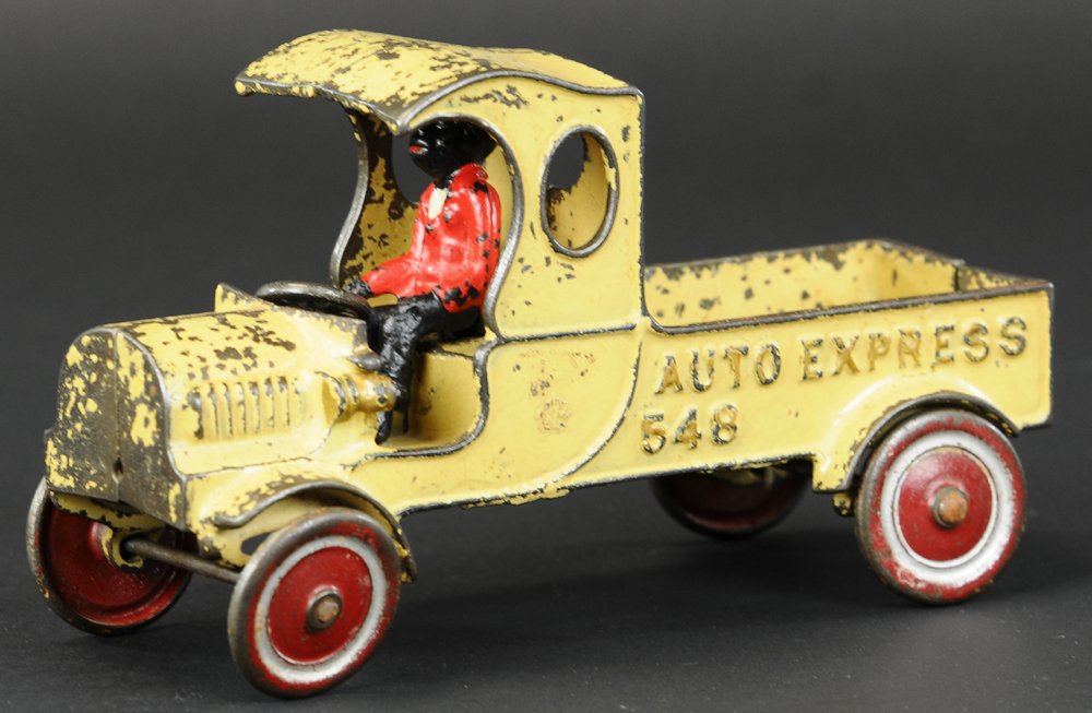 KENTON EARLY AUTO EXPRESS TRUCK: c. mid-1920's, cast iron, painted in cream color body, seated driver, ornate cab design, open bed body, embossed "Auto Express 548," disc wheels have painted red centers. 9" l.