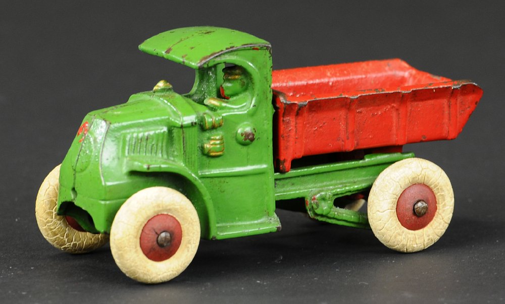HUBLEY MACK DUMP TRUCK: Cast iron, small version green Mack cab with embossed driver, red dump body able to tilt for unloading, rubber tires. 5" l.