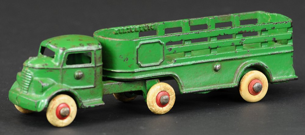 KENTON TRACTOR TRAILOR: Cast iron, painted in green overall, cab over model pulls separate open top stake trailer, rubber wheels. 7 3/4" l.