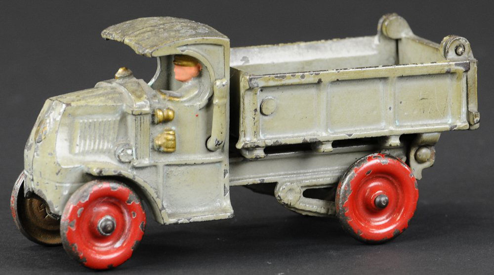 HUBLEY MACK DUMP TRUCK: circa 1930's, cast iron, painted in grey overall, strong spring action when lever is depressed for tilting, cast driver is painted, repainted red cast iron disc wheels. 7" l.