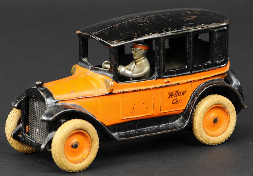 ARCADE DOUBLE BELTED YELLOW CAB: circa 1927, cast iron, painted in orange body, black roof and running boards, stenciled "Yellow Cab" on doors, cast spare on trunk, rubber tires with disc wheels, painted centers, nickel driver. 7 1/2