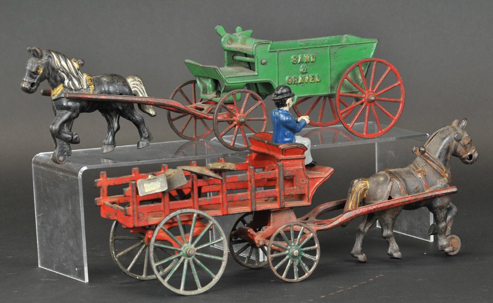 LOT OF TWO KENTON HORSE DRAWN WAGONS: Cast iron, includes green Sand & Gravel wagon, and red stake wagon, both pulled by solo horse. Each 15" l.