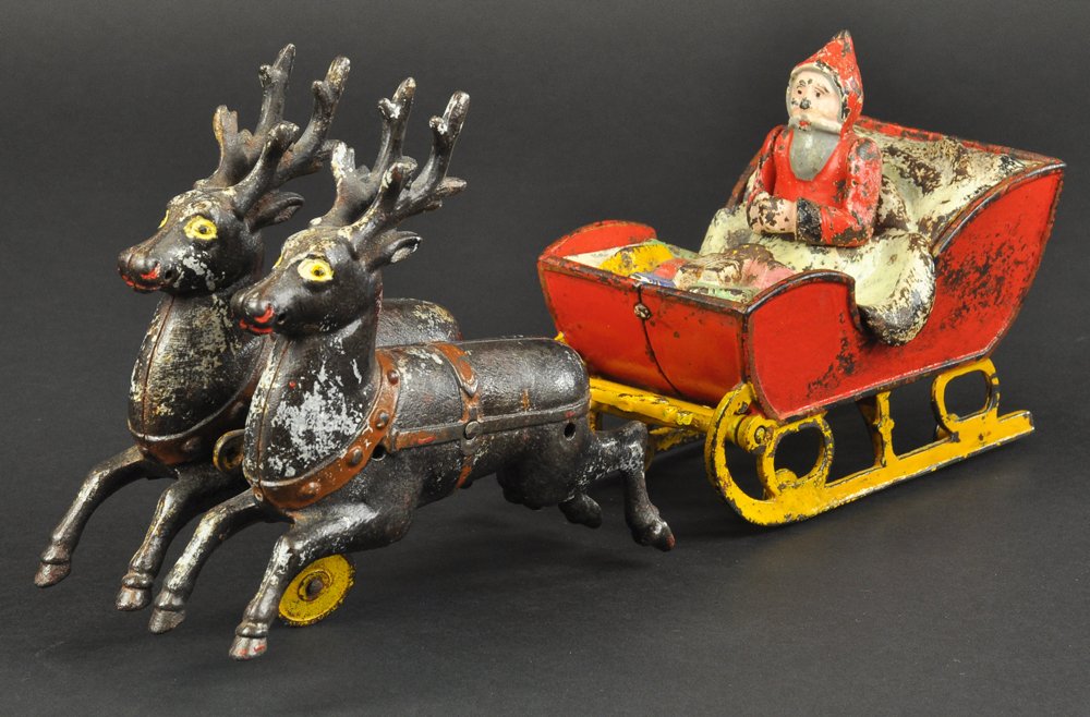 KYSER & REX SANTA AND REINDEER: Colorfully molded and painted cast iron toy, features two reindeer drawing Santa in red sleigh with yellow runners, embossed detail to blanket and gifts make this an incredible visual toy design, very