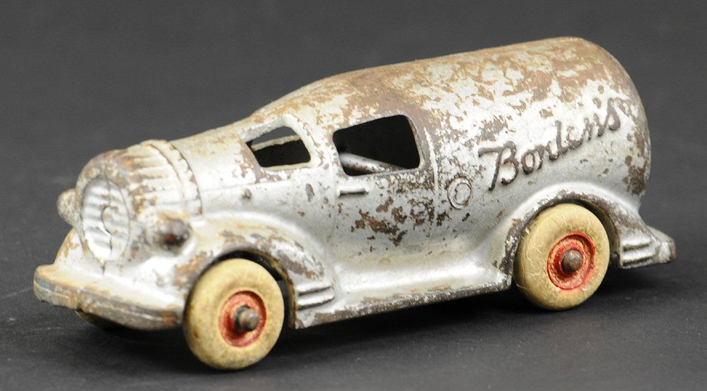 BORDEN'S MILK BOTTLE TRUCK: Arcade, cast iron, painted in light silver overall, rubber tires, unique figural milk bottle body design with "Bordens" embossed on sides, scarce example. 6" l.