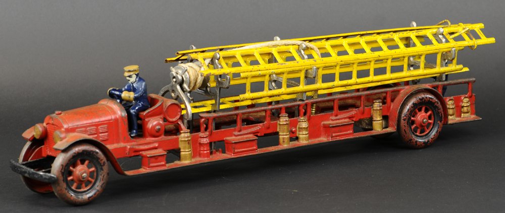 KENTON LADDER TRUCK: Large scale open red fire truck, one of the largest of service toy trucks, bench seating, contains ladder supports and well cast details of fire apparatus on sides, disc wheels are painted in black wi