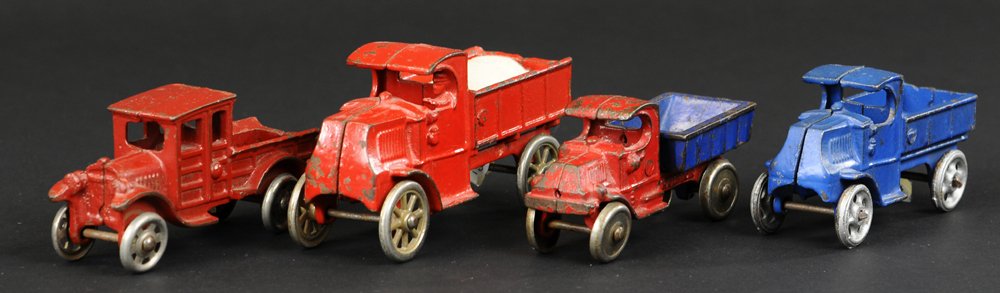 GROUP OF FOUR CAST IRON WORK TRUCKS: Features Champion red and blue Mack dump, two Hubley Mack utility trucks, and a red A.C. Williams wood sided open bed Model 'A' truck. 4 1/4" to 5 1/2" l.
