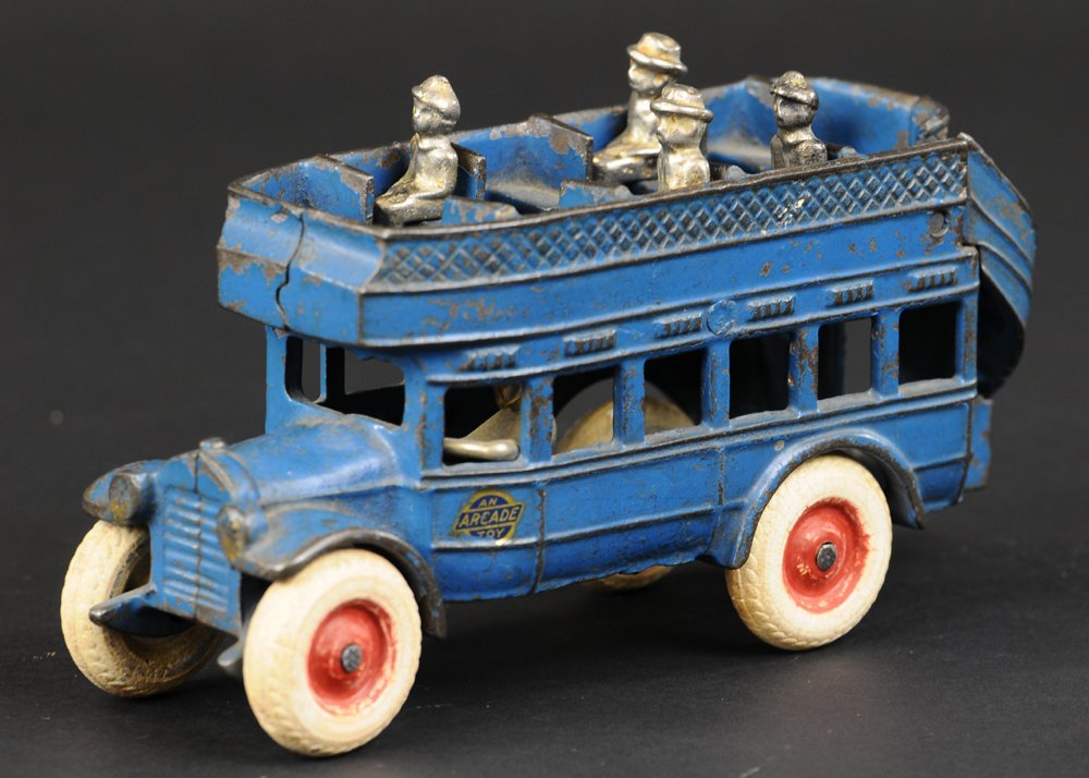 ARCADE DOUBLE DECKER BUS: Cast iron, painted in blue overall, cast rear stairway, open roof bench seating, original decal and white rubber tires with red centers, nickel plated driver and four passengers, Arcade decal on side.