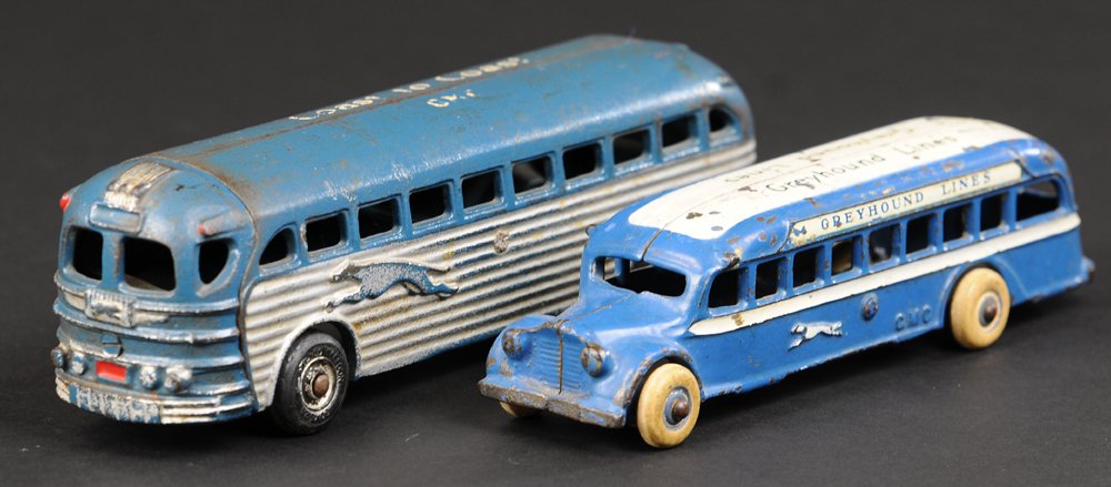 TWO ARCADE GREYHOUND BUSES: Cast iron, both painted in blue, one with silver side band, roof reads, "Coast to Coast," other example is a GMC, roof lettered "Greyhound Lines," both have rubber tires. 7 1/2" to 8 1/2" l.
